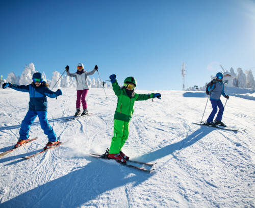 Mother with kids are skiing together down the ski slope. Everybody is laughing happily. 
Sunny winter day.
Nikon D850